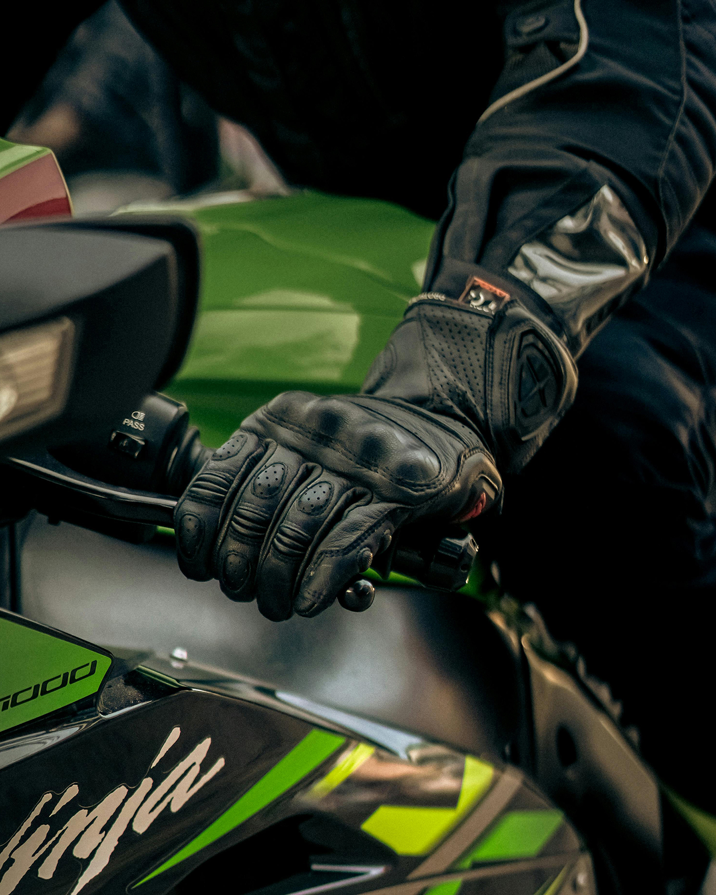 Mano con guante sujetando embrague de moto